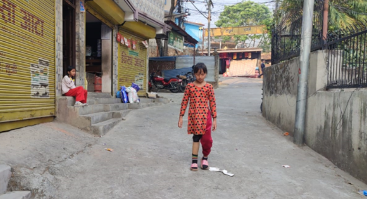 Man Kumari walking down the street with her prosthetic limb.