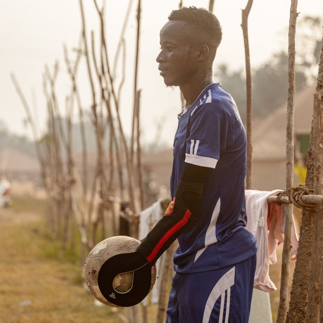 Image of prosthetic user playing football against a warm sunset Cover Image