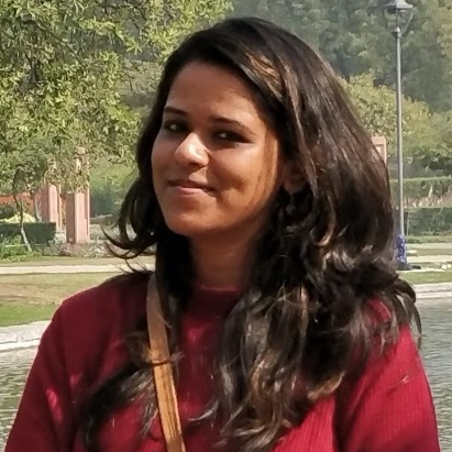 Headshot of Prabha Roy, Prabha has long dark brown hair and is wearing a red top.