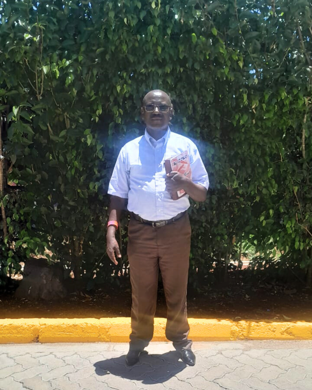 Charles Njoogu standing in front of a bush Cover Image