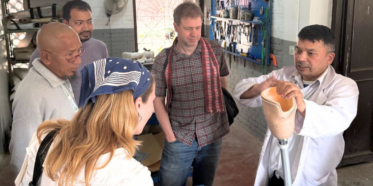 Project team members are being shown a prosthetic leg in the Kathmandu university design lab by one of their professors