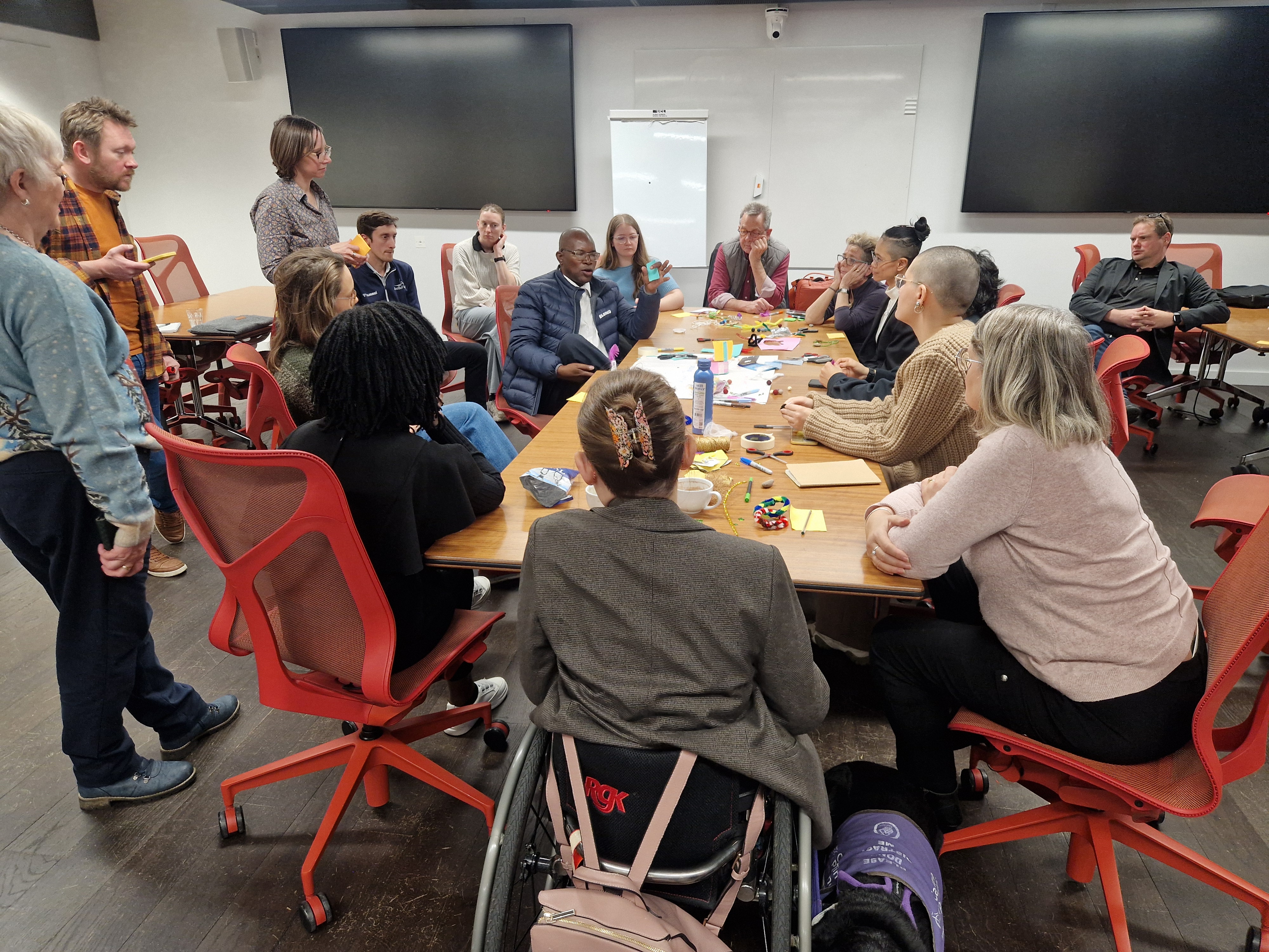 Storytelling workshop, deep in discussion with participants in conversation around the table