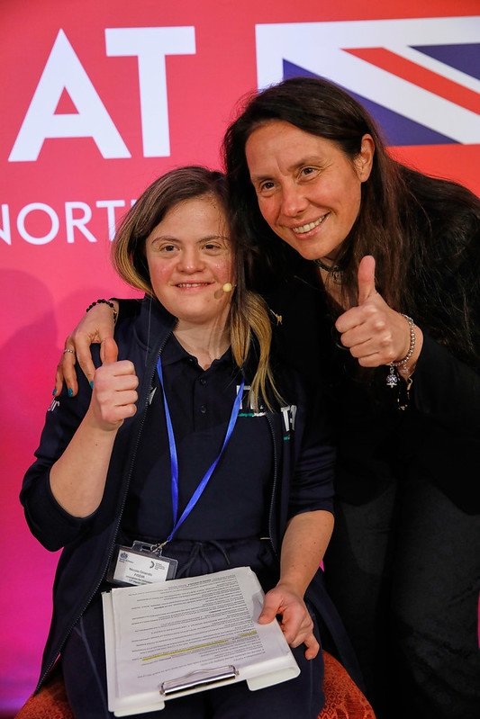 Nicole Orlando and Minister Alessandra Locatelli smiling to camera on stage