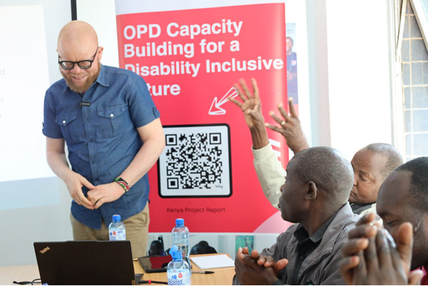 A person stood in front of a workshop poster.