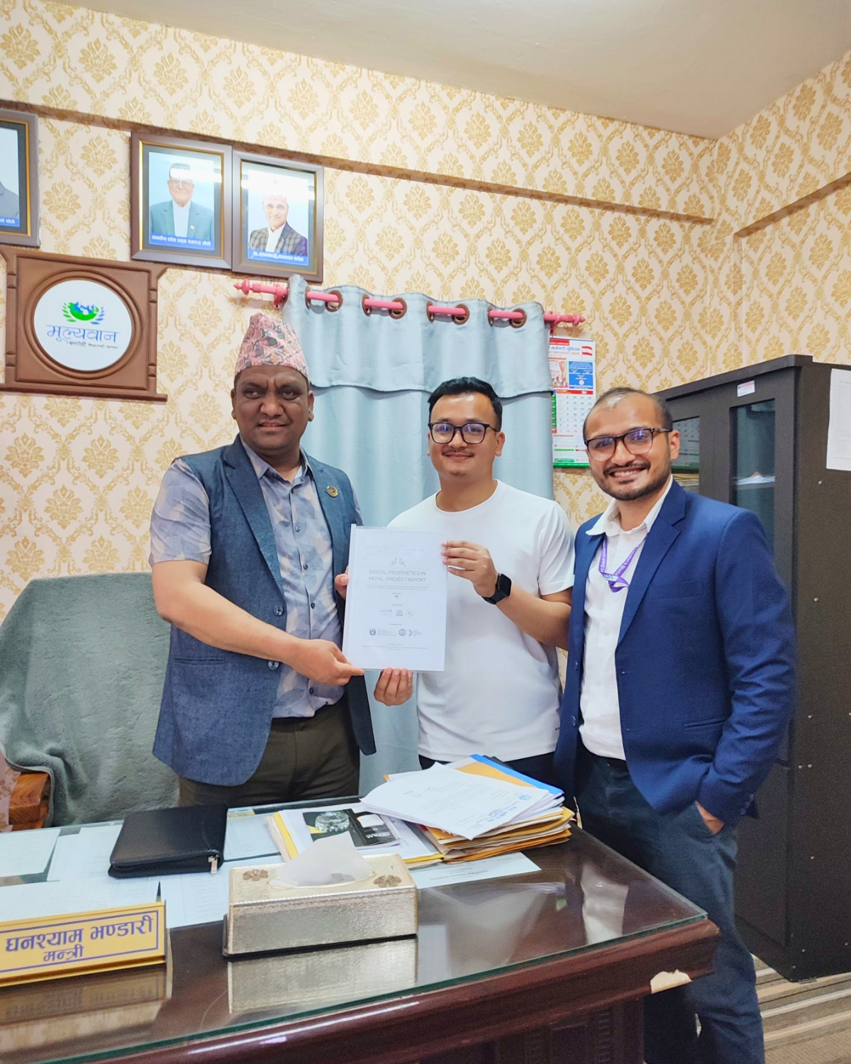 Three people, including the Minister for Social Development of Karnali Province posting for a photo Cover Image