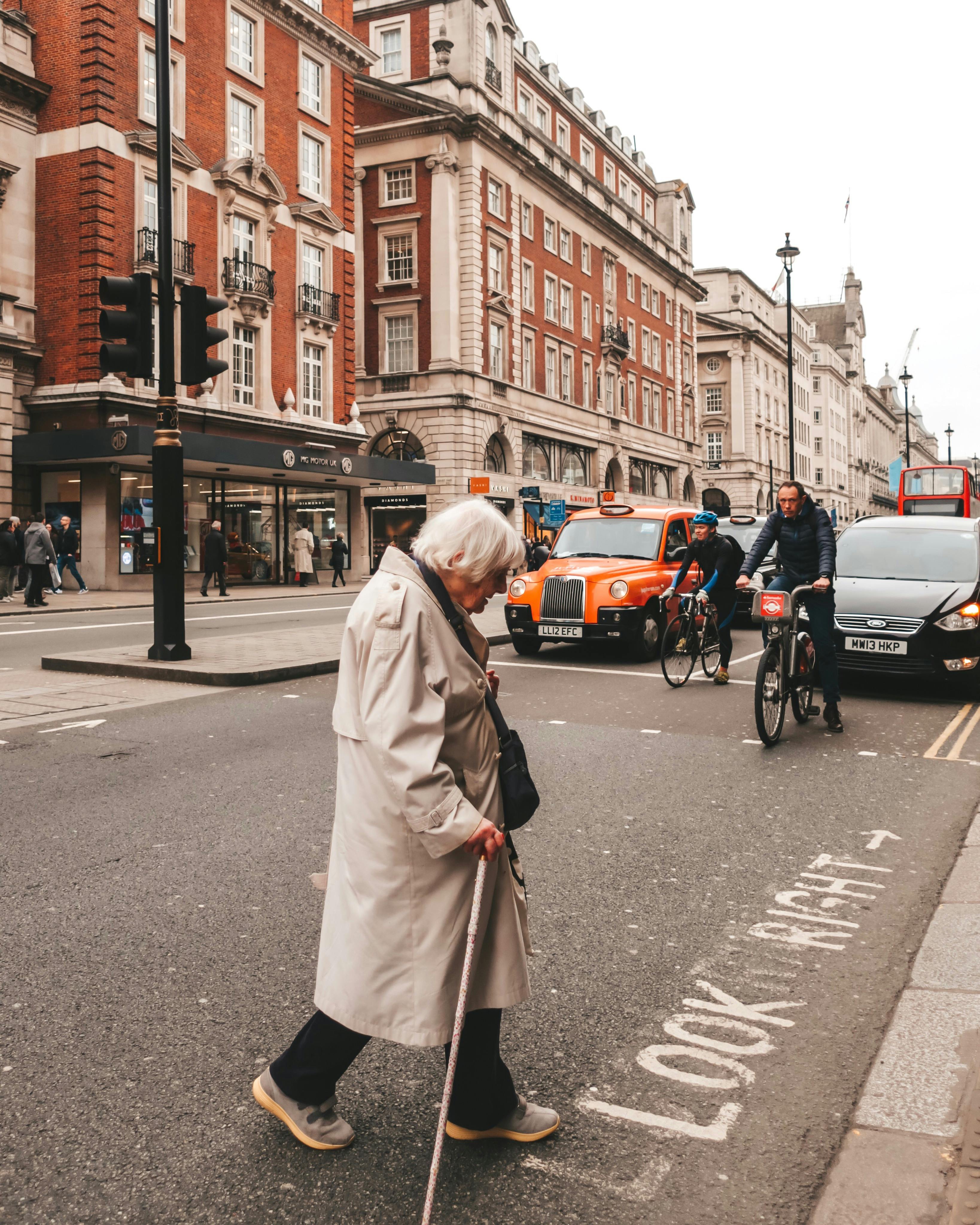 An Elderly Woman with Cane Crossing the Road Cover Image